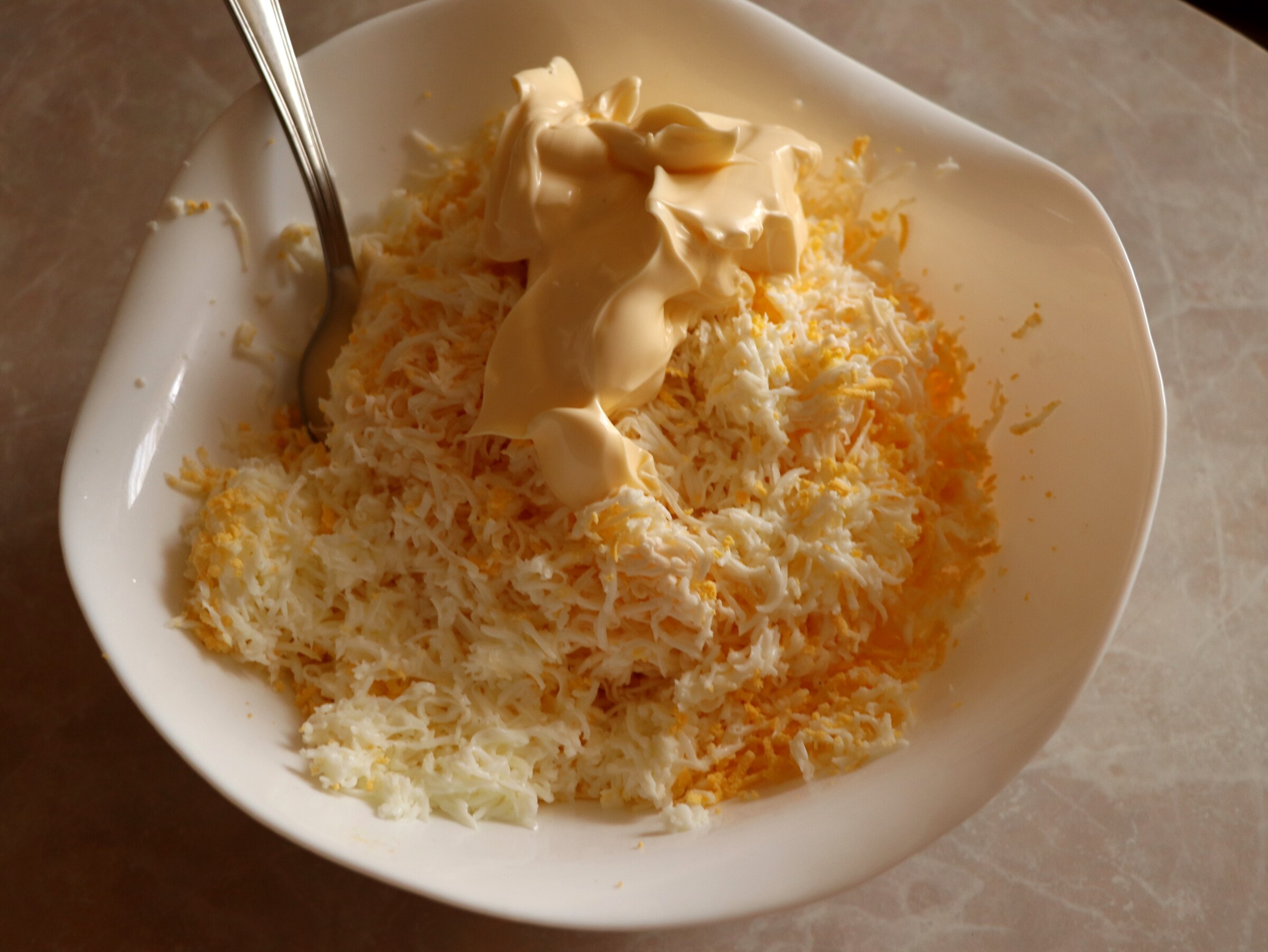 Step 1. Fine-grate the processed cheese. Crab-stick starter