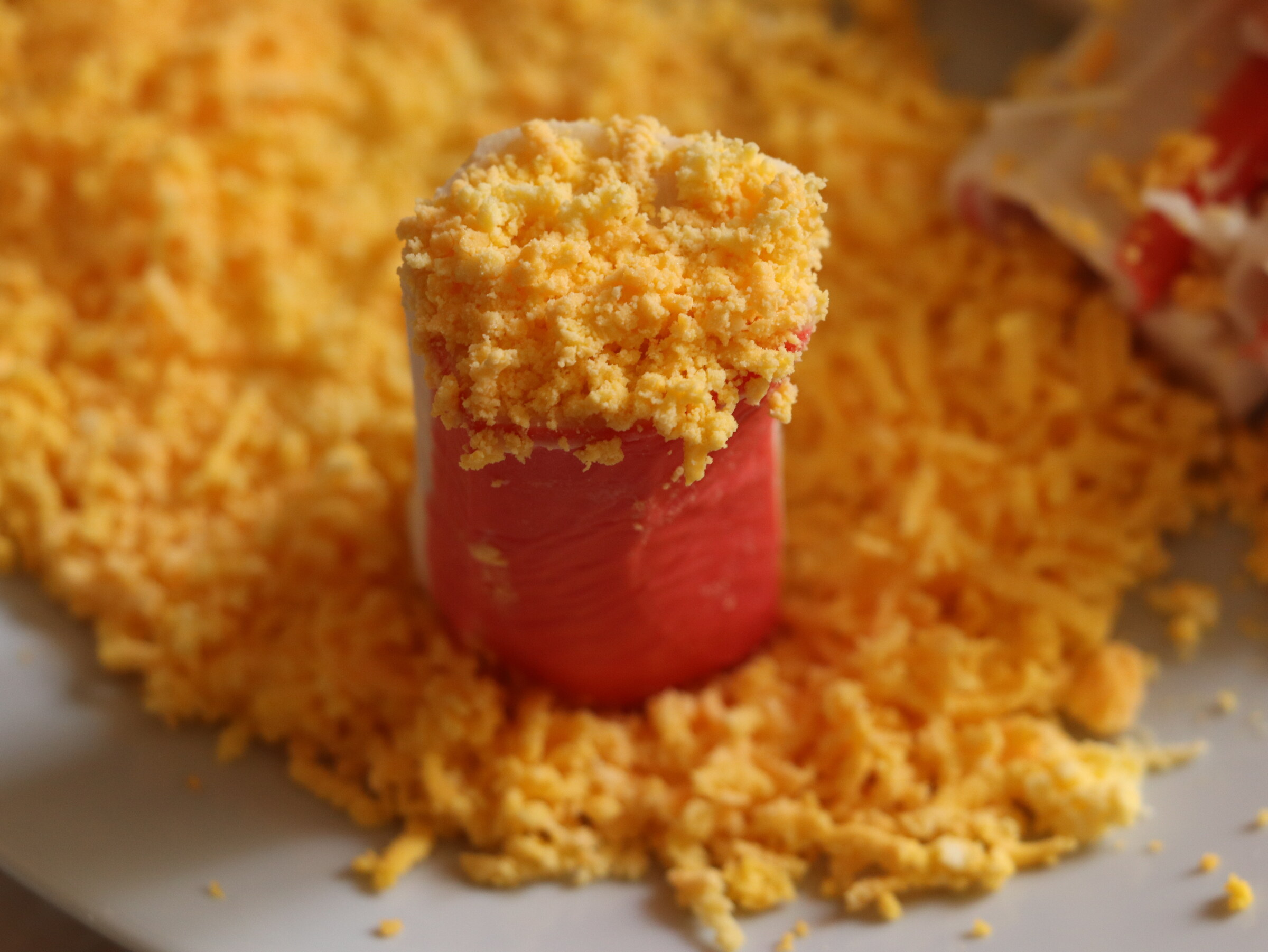 Step 4. Fine-grate the yolks separately and dip the cut sides in them. Crab-stick starter