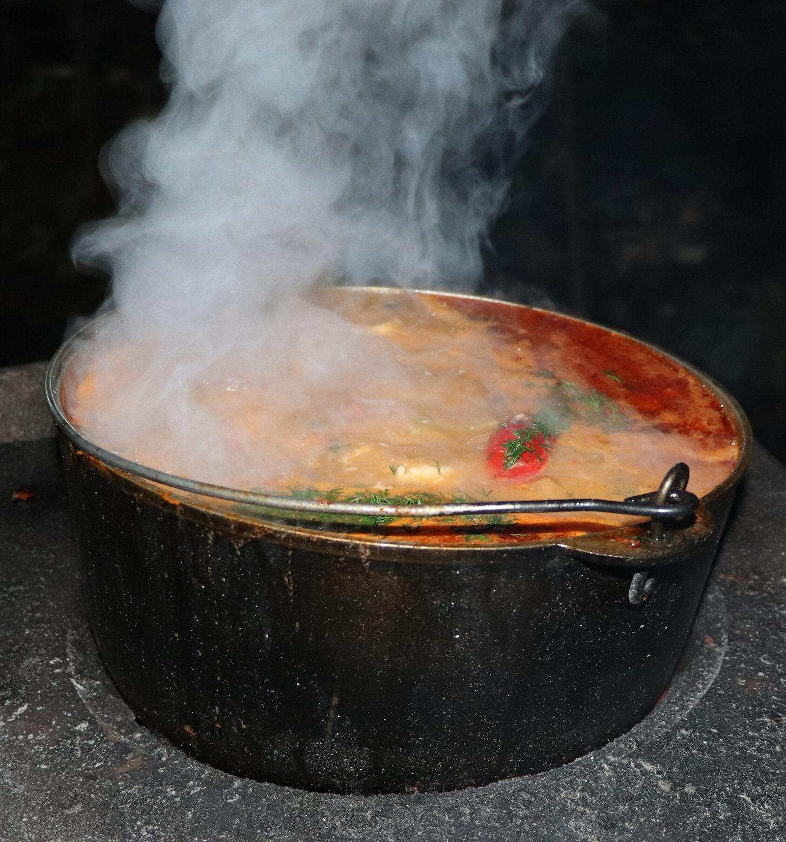 Step 9. Add tomato paste to the paprika, fry for another 30 seconds and combine with. Fish solyanka in a kazan over the fire