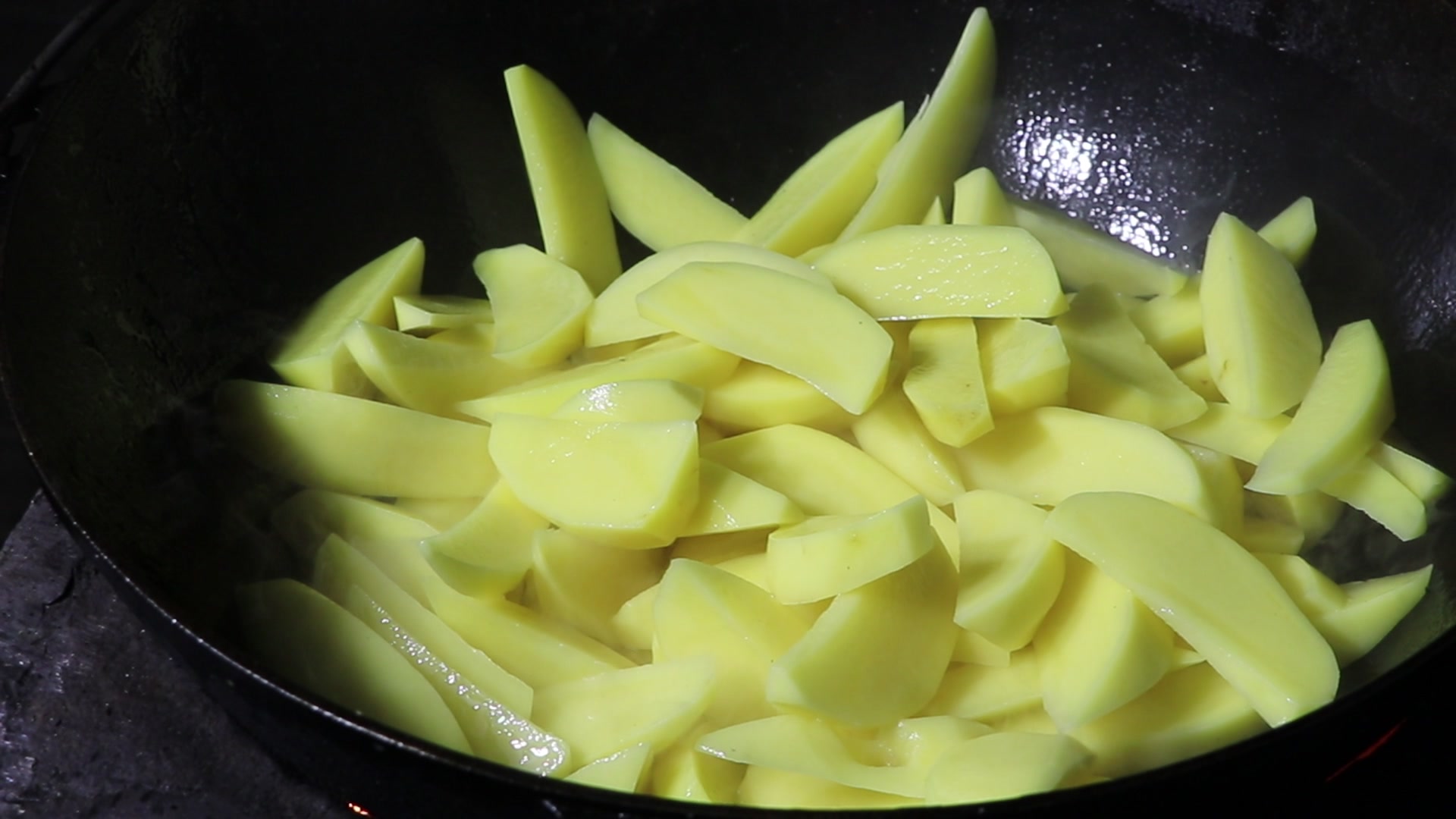 Step 2. Cut the potatoes into large slices and fry in vegetable oil until almost cooked. Fried potatoes in a kazan over the fire