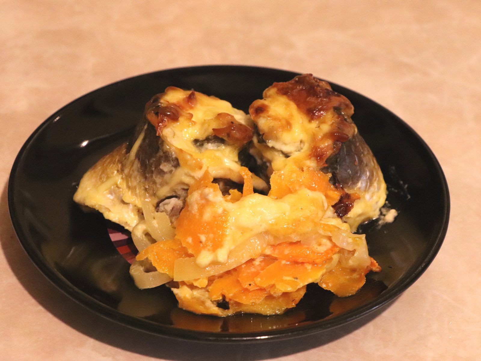 Grey mullet rolls with cheese on a bed of vegetables
