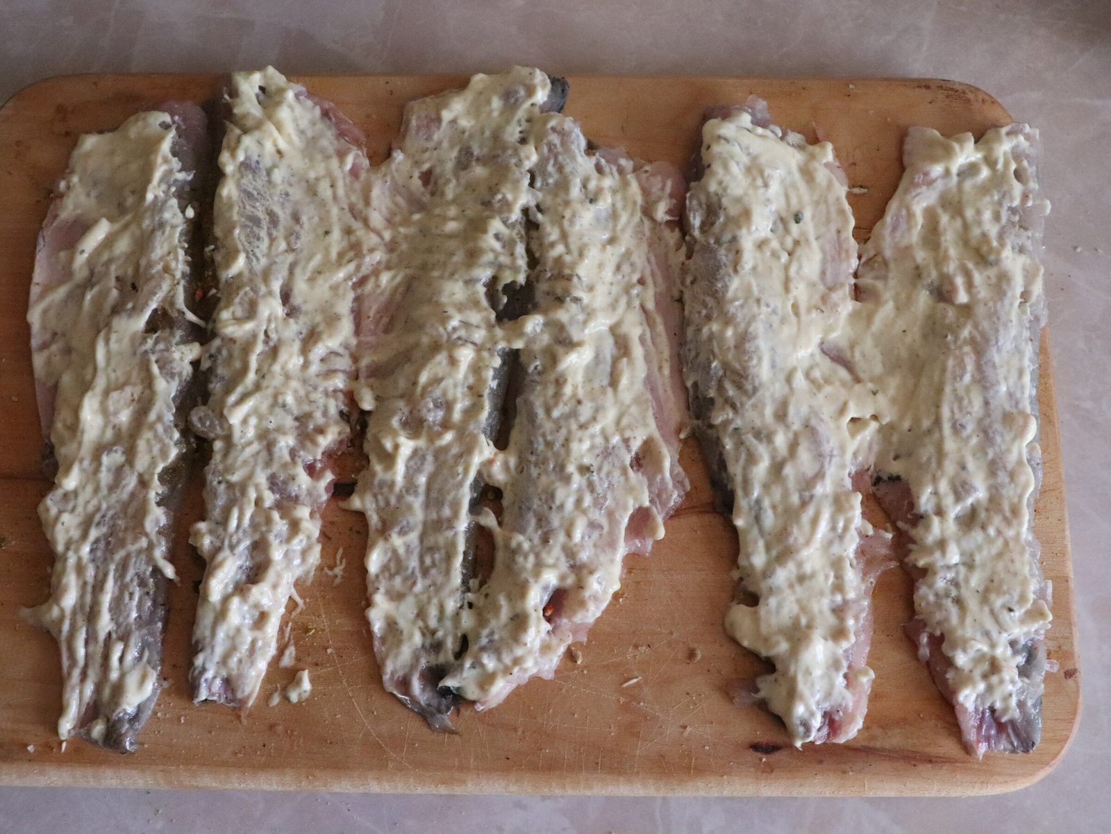 Step 2. First, let's prepare the fillet - to do this, you need to cut the fish carcass. Grey mullet rolls with cheese on a bed of