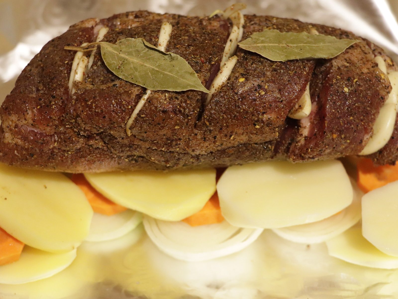 Step 4. Insert garlic slices into the cuts. Juicy brisket on a bed of vegetables