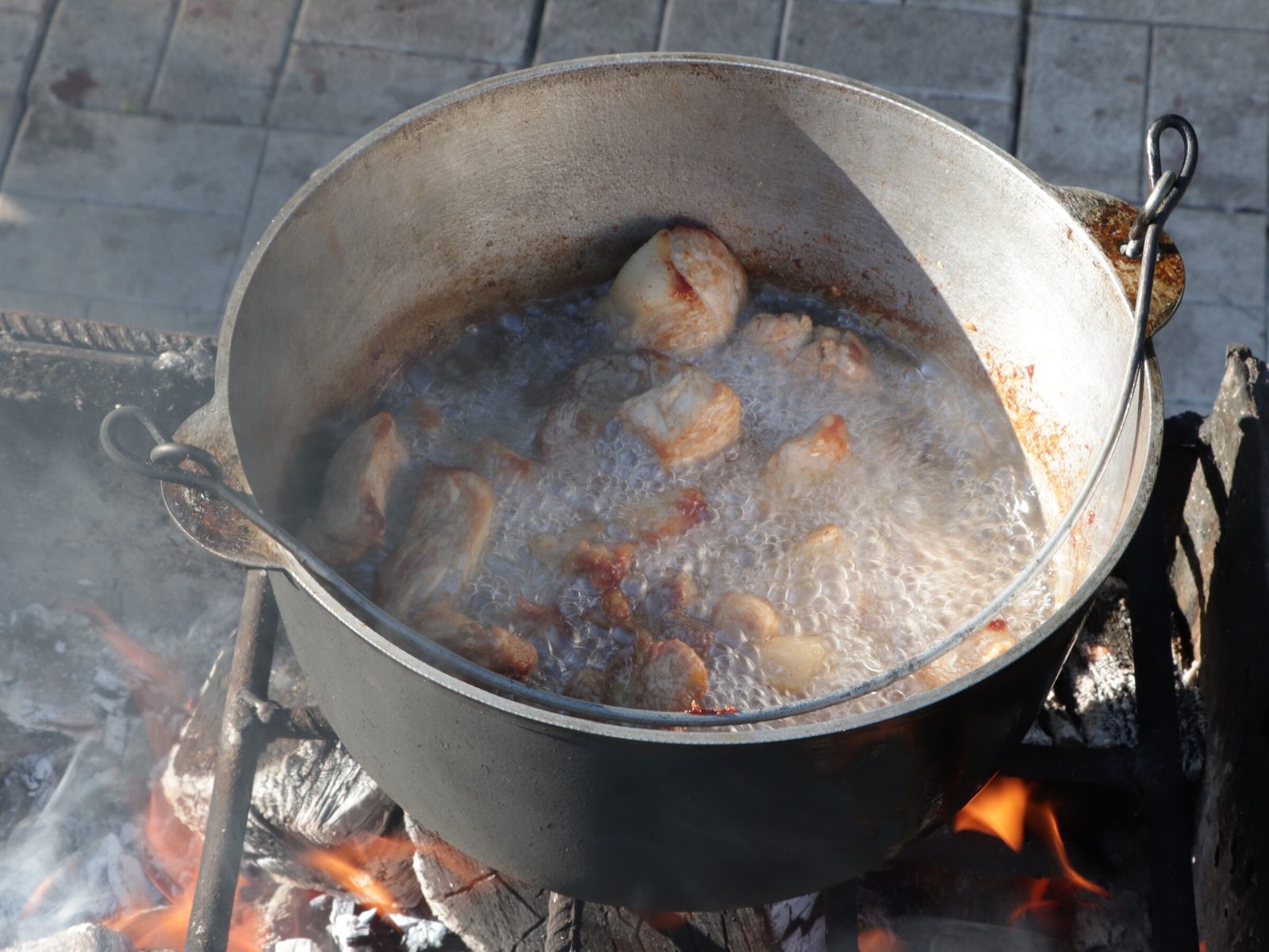 Step 3. Add the onion to the golden meat and stir until the onion becomes transparent. Lagman in a kazan over the fire