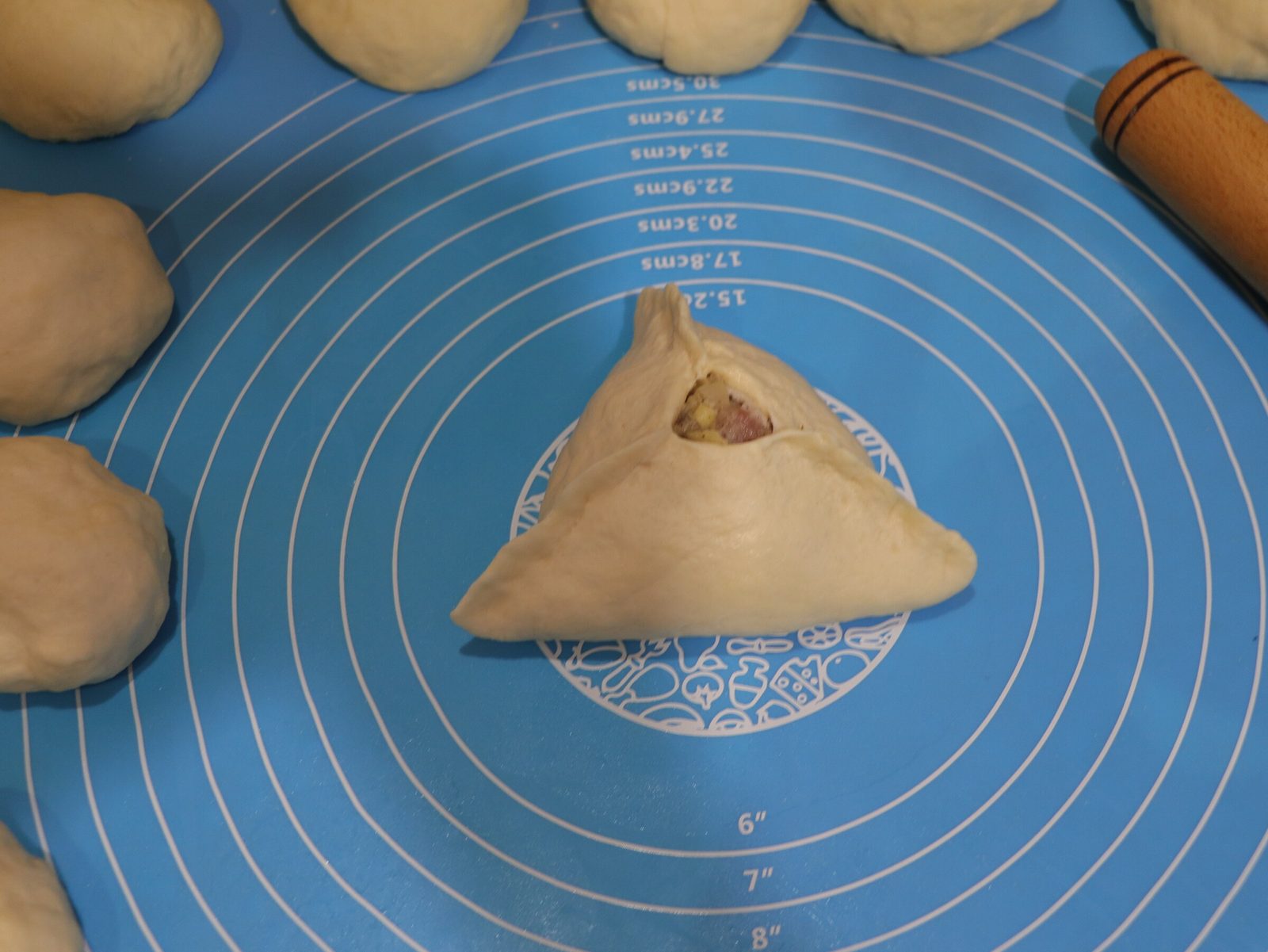 Step 4. We pinch the dough on three sides, forming a triangle with a hole in the middle. Lazy meat triangles