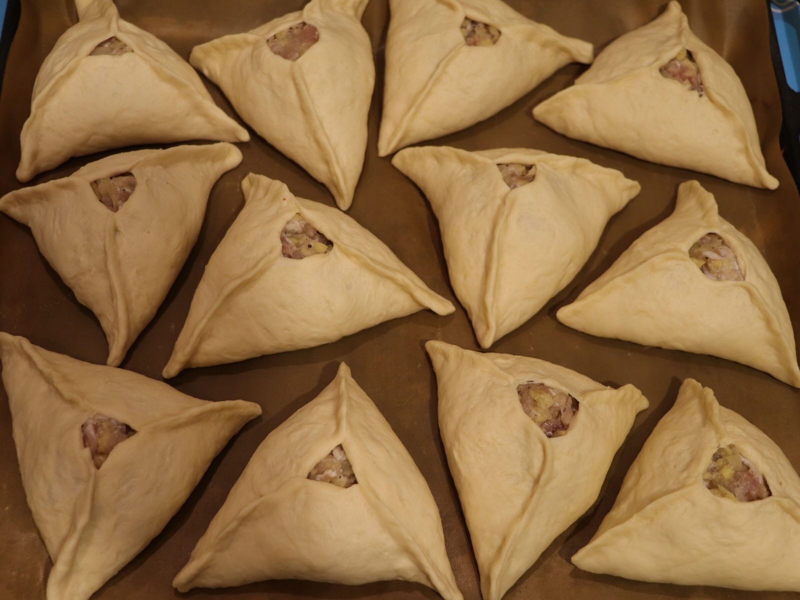Step 5. Place the triangles on a baking tray lined with baking parchment or a Teflon. Lazy meat triangles