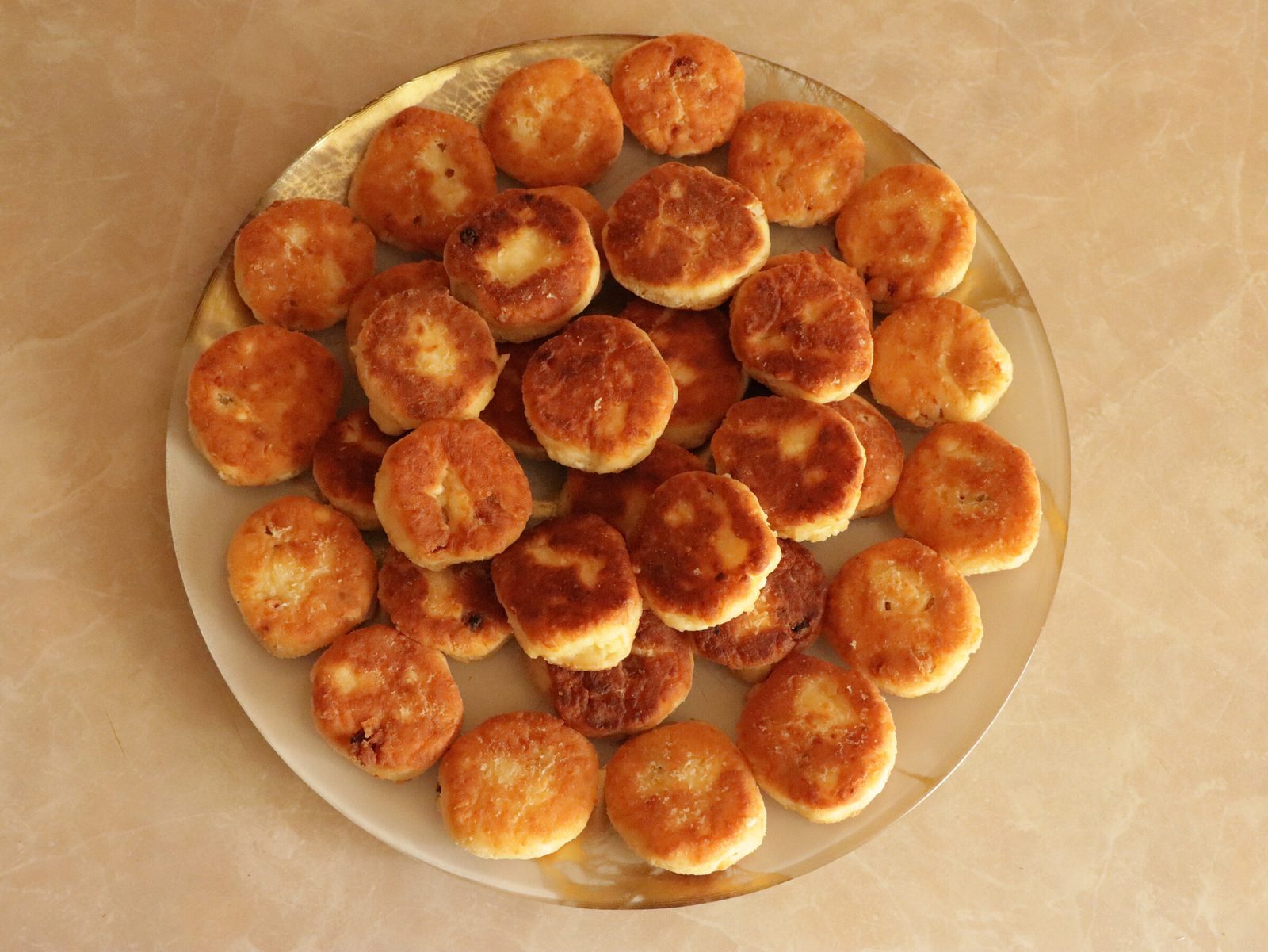 Step 2. In a deep bowl mix curd cheese, bicarbonate, sugar, vanilla sugar and egg. Syrniki (curd-cheese pancakes)