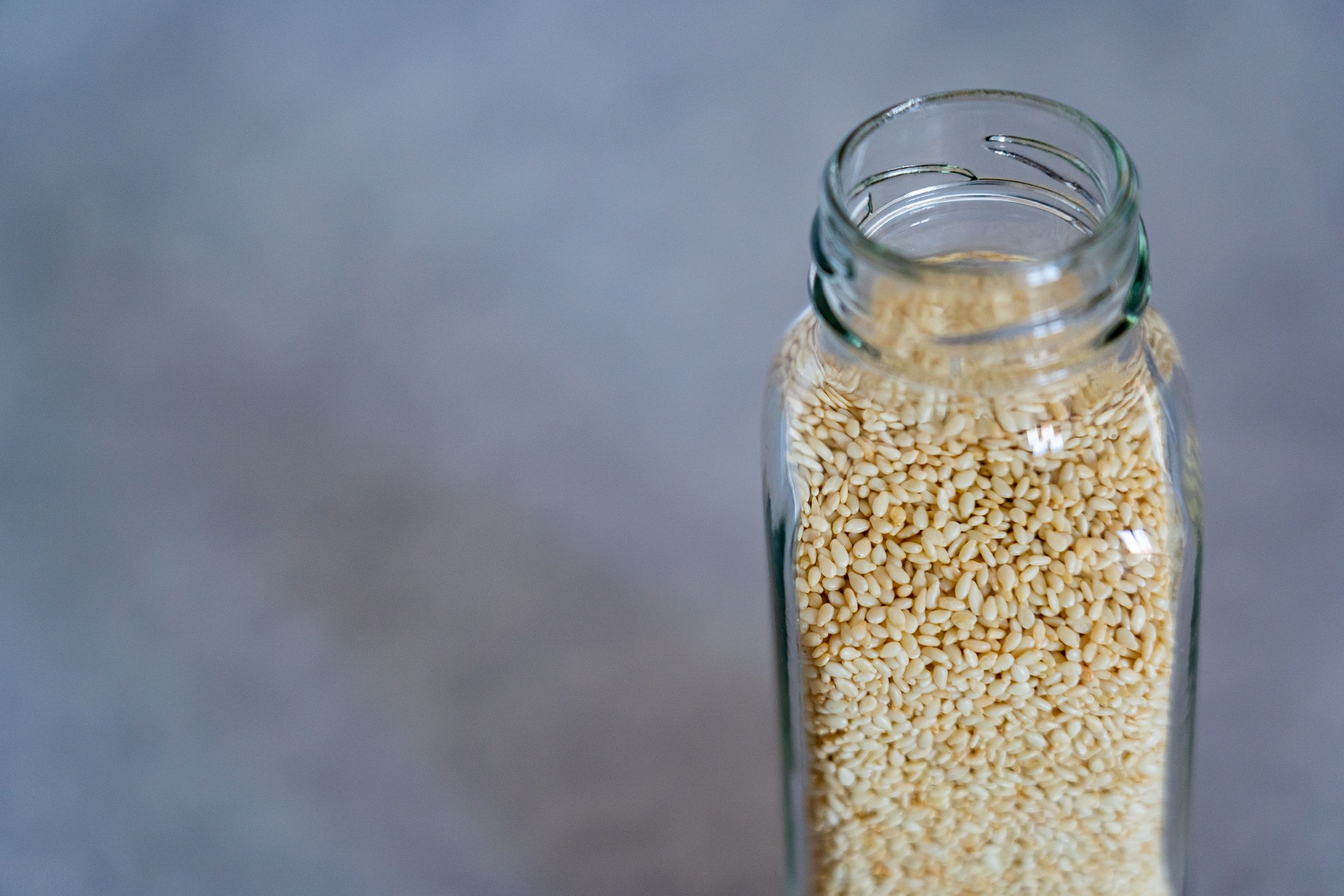 A quiet jar of sesame seeds — lid on, cool shelf