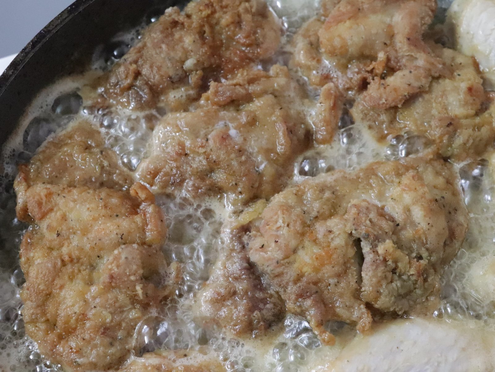 Step 5. Salt and pepper the finished pieces, coat them with mayonnaise and put them in. Juicy chicken in the pan