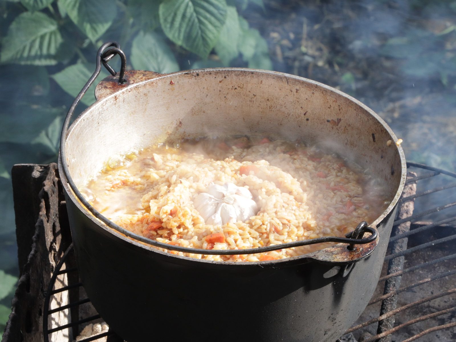 Step 7. After 30 minutes, add rice and add water so that it covers the rice by 2 cm. Plov in a kazan over the fire